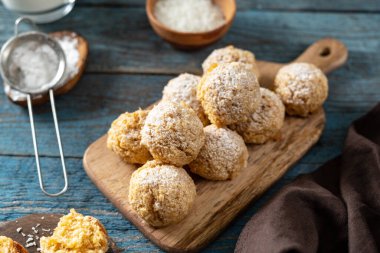 Ev yapımı hindistan cevizi kurabiyeleri servis tahtasında mavi ahşap mutfak arka planında