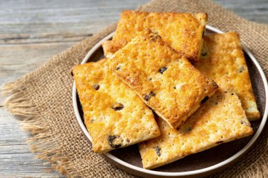 Açık gri ahşap mutfak arka planında kuru üzümlü poğaça. Lezzetli ev yapımı tatlı hamur işleri