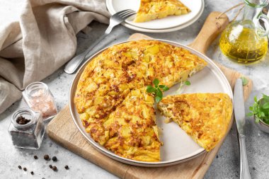 Frittata ya da seramik tabakta hafif bir mutfak arka planında patates turtası. Geleneksel İtalyan lezzetli ev yapımı yumurta tabağı mutfak masasında.