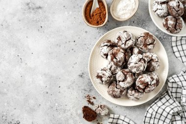 Mutfak masasındaki beyaz tabakta ev yapımı çikolata ve kahve kırışık kurabiyeler. Geleneksel Amerikan kurabiyeleri Noel için çatallı ve pudra şekerli mutfak zemininde. Kopyalama uzayından en üstteki görünüm