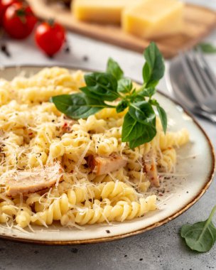 Krema soslu makarna seramik tabakta ve hafif mutfak arka planında. Geleneksel İtalyan yemeği zührevi mutfak masasının üzerindeki kasede.