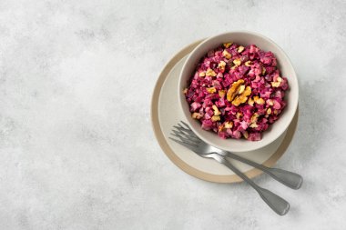 Salatalık turşulu pancar salatası, ceviz, elma ve mayonez açık gri mutfak masasında. Üst görünüm