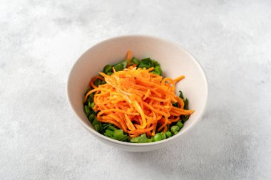 Yeşil bezelyeli bir kase salata, havuç turşusu ve parlak mutfak masasında zeytinyağlı maydanoz. Sağlık ve kilo kaybı için enfes sağlıklı salata.