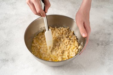 Açık gri mutfak arka planında puding ya da yulaf ezmeli turta karışımı.