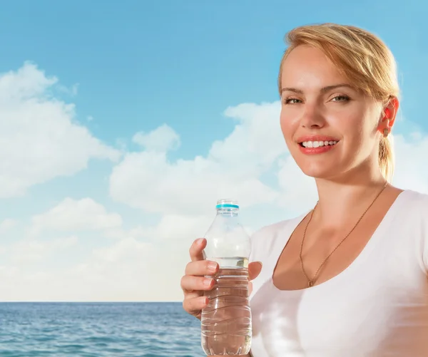 Beautiful woman smiling with water bottle in hand