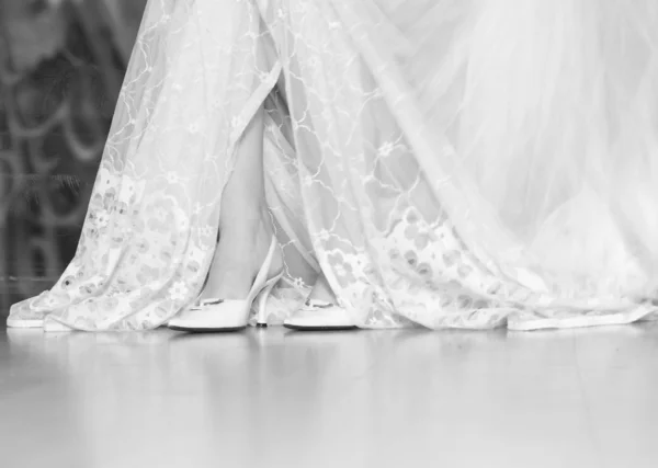 Frauenbeine im Hochzeitskleid — Stockfoto
