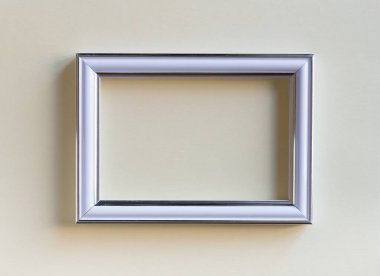 Sade bej bir arkaplanda boş beyaz resim çerçevesi. Sanat sergisi için boş poster modeli. Kimse yok.