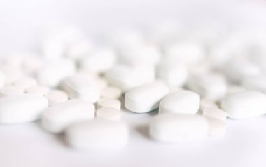 Beyaz arka planda bir sürü beyaz hap var. Sağlık.