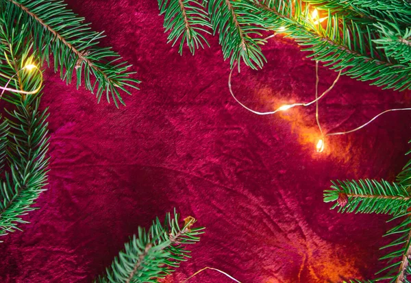 クリスマスの背景 赤い背景にコーンとクリスマスボールと緑の松の枝 境界線とコピースペース トップビューを持つ創造的な組成 — ストック写真