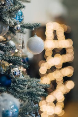 Noel arkaplanı, yeşil çam dalları, şenlik arka planı. Sınır ve kopyalama alanı ile yaratıcı bileşim. Ampullerden gelen bokeh ışıklarıyla Noel süslemesi