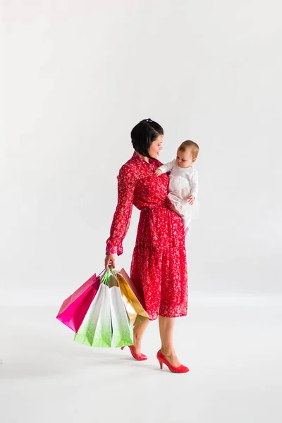 Жінка Тримає Пакети Мама Маленькою Дитиною Йдуть Покупками Білий Фон — стокове фото