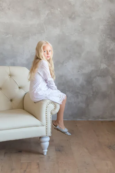 Маленька Блондинка Принцеса Білій Повсякденній Сукні Сидить Білому Шкіряному Дивані — стокове фото