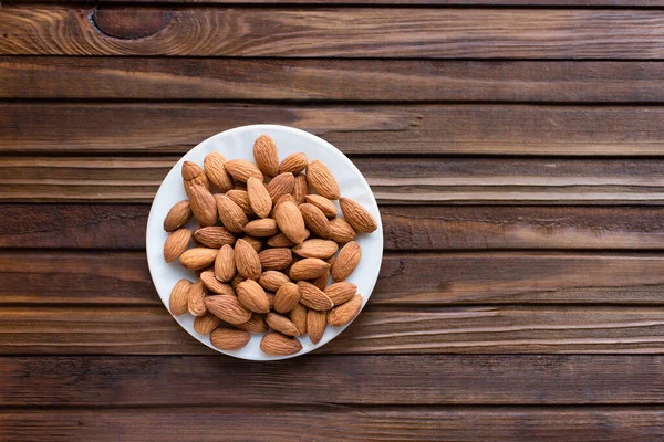 Almond Dalam Mangkuk Latar Belakang Kayu — Stok Foto