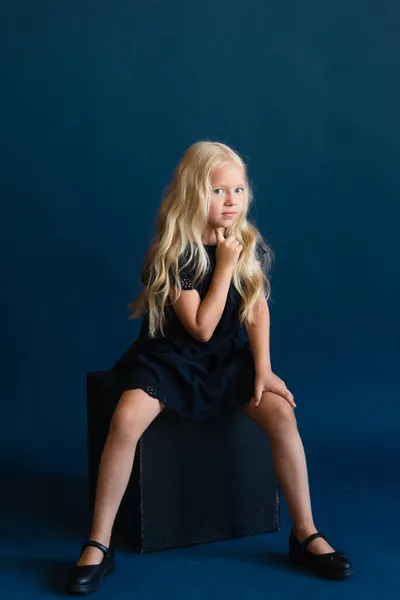 Όμορφη Ξανθιά Κοπέλα Ένα Σκούρο Μπλε Φόρεμα Ένα Στερεό Μπλε — Φωτογραφία Αρχείου