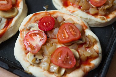 Mini pizza. Pişirmeden önce altı dilim pizza. Fırına koymadan önce kurusıkı yemek tepsisi..