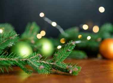 Noel arkaplanı, yeşil çam dalları, şenlik arka planı. Sınır ve kopyalama alanı ile yaratıcı bileşim. Ampullerden gelen bokeh ışıklarıyla Noel süslemesi