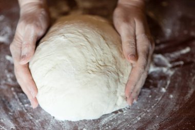 Kadın eli para kazanıyor. Hamur yoğurma işlemi. Hamur, doğal ekşi hamura dayanır. Buğday hamuru. Fermantasyon.
