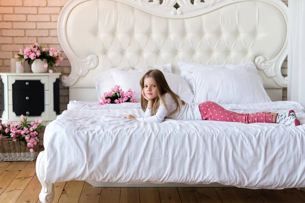 Meisje Pyjama Ligt Een Bed Met Wit Linnengoed Bloemendecor — Stockfoto