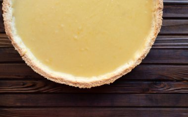 Limonlu, yuvarlak, kısa hamurlu pasta turtası. Tahta kahverengi bir arka planda.