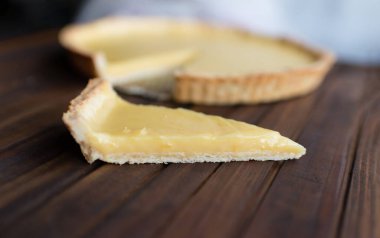 Limonlu, yuvarlak, kısa hamurlu pasta turtası. Tahta kahverengi bir arka planda.