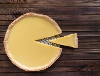 Limonlu, yuvarlak, kısa hamurlu pasta turtası. Tahta kahverengi bir arka planda.