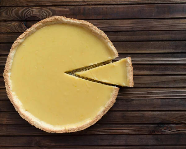 Limonlu, yuvarlak, kısa hamurlu pasta turtası. Tahta kahverengi bir arka planda.