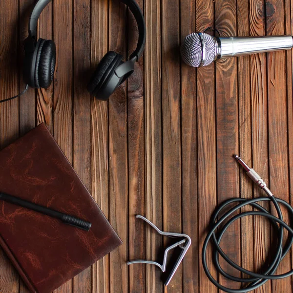 音楽のテーマ 木製の背景にヘッドフォン ノートパッド ジャックとカポ — ストック写真