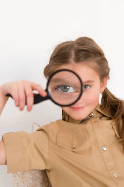 Gelukkig Meisje Kijkt Door Een Vergrootglas Een Lichte Achtergrond Onderzoeks — Stockfoto
