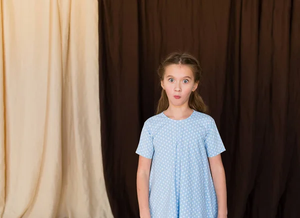 幸せな興奮した感情的な女の子の肖像画で青無地のドレス — ストック写真