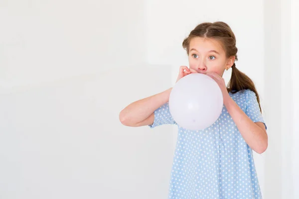 Kind Meisje Een Blauwe Jurk Opblaast Een Ballon — Stockfoto
