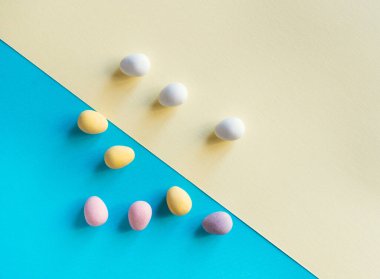 Renkli Paskalya yumurtaları, şık, açık bir arka planda. Minimum konsept. Metin için kopyalama alanı olan kart.