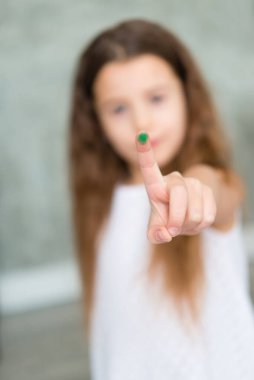 Parmağından bakan bir kızın yakın çekimi.