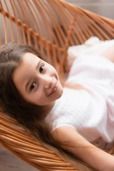 Aranyos Kislány Egy Fonott Fából Készült Székben Pihen — Stock Fotó
