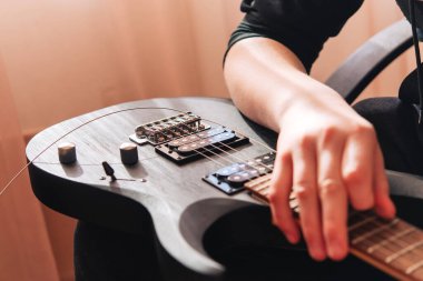 Elektro gitarın tellerini değiştirmek. Müzik teması.