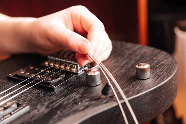 Elektro gitarın tellerini değiştirmek. Müzik teması.
