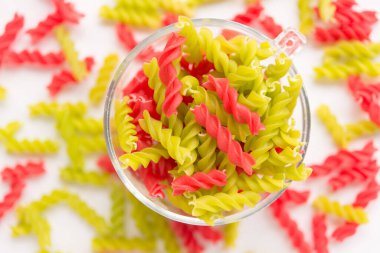 Fusille ve Rotini 'nin arka planında beyaz cam bir kase içinde. makarna kolorata