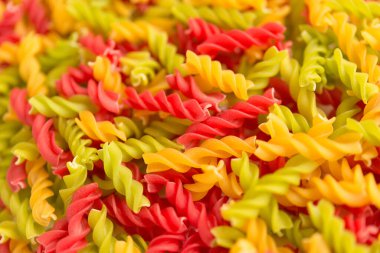 Fusille ve Rotini 'nin arka planında beyaz cam bir kase içinde. makarna kolorata