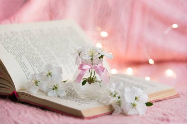 Pembe arka planda beyaz küçük çiçekli eski bir kitabı aç