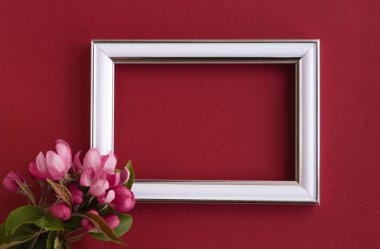 Güzel bir çiçek aranjmanı. Açık pembe çiçekler, boş fotoğraf çerçevesi kırmızı arkaplandaki mesajlar için. Düğün için. Doğum günü. Sevgililer Günü. Anneler Günü. Üst görünüm, boşluk kopyala