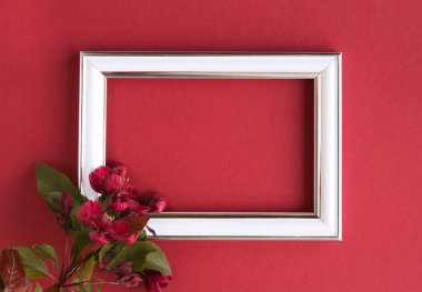 Güzel bir çiçek aranjmanı. Açık pembe çiçekler, boş fotoğraf çerçevesi kırmızı arkaplandaki mesajlar için. Düğün için. Doğum günü. Sevgililer Günü. Anneler Günü. Üst görünüm, boşluk kopyala