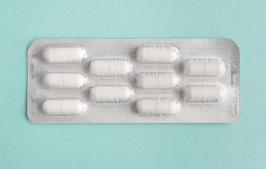 Mavi arka planda beyaz hap kapsülleri kabarcığı