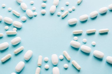 Pastel arka planda beyaz haplar. Kapsüller ve yuvarlak haplar yakın plan. Sağlık ve İlaç Hizmetleri.