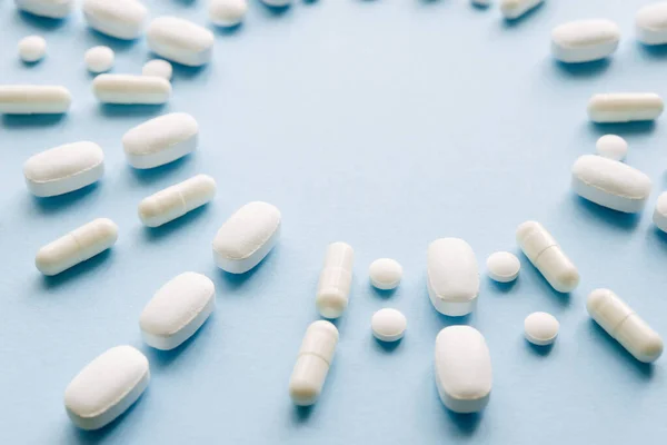 Pílulas Brancas Fundo Azul Pastel Cápsulas Comprimidos Redondos Close Cuidados — Fotografia de Stock