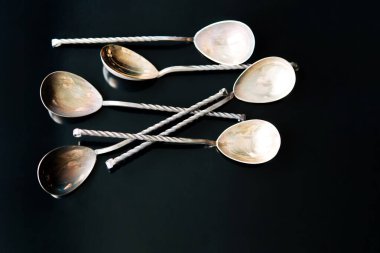 Siyah arkaplanda gümüş renkli kaşıklar