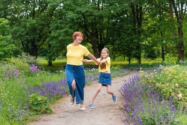 夏の公園の道を歩く積極的な母親と娘 — ストック写真