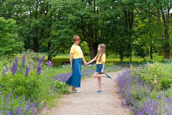 夏の公園の道を歩く積極的な母親と娘 — ストック写真