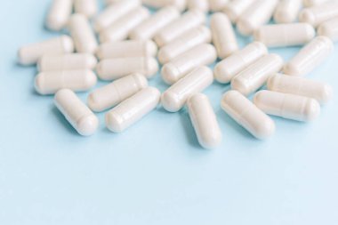 Mavi arka planda organik bitkisel kapsüller. Metin için kopyalama alanı olan tıbbi arkaplan