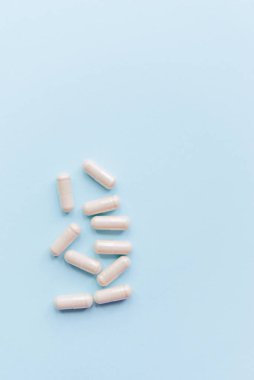 Mavi arka planda organik bitkisel kapsüller. Metin için kopyalama alanı olan tıbbi arkaplan