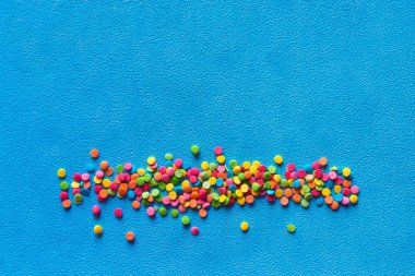 Renkli şekerlerin arkaplanı. Dondurma ve kekler için gökkuşağı malzemesi. Üst Manzara. Boşluğu kopyala.