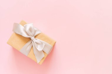 Pastel pembe arka planda bir hediye kutusu. Doğum günü partisi, sevgililer günü ya da anneler günü tebrik kartı. Üst görünüm, düz görünüm, kopyalama alanı